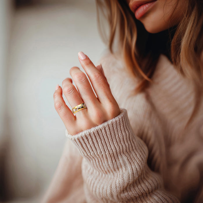 Gold moon-and-star diamond ring on a woman's finger, close-up