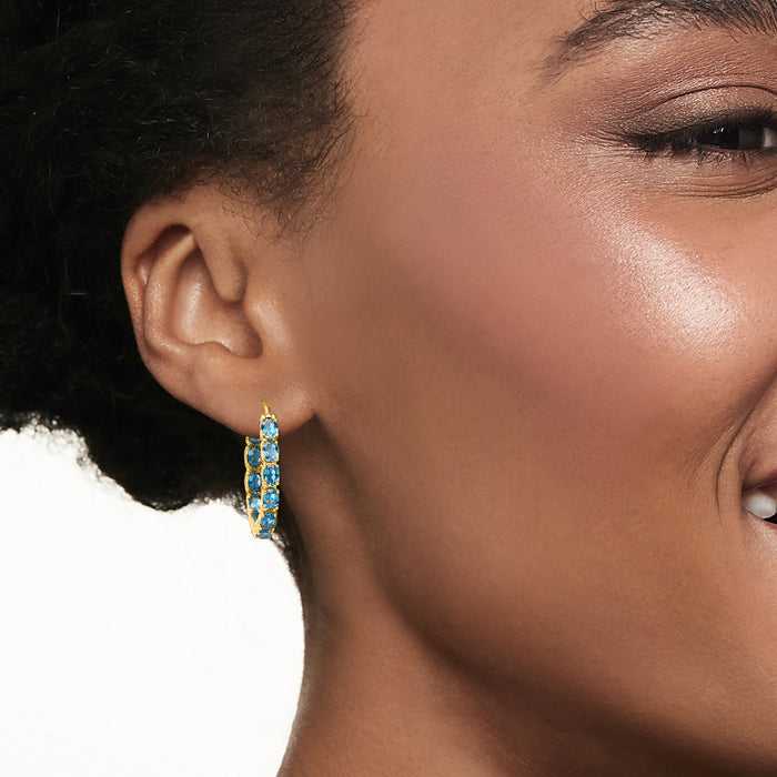 Blue topaz set gold hoop earrings on ear, small inside-out hoop detail