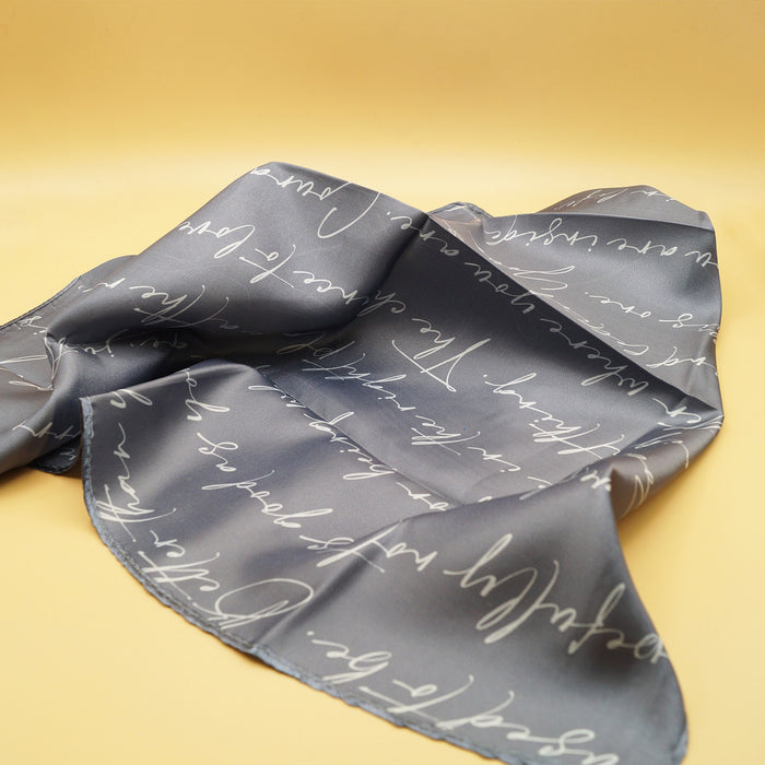 a gray scarf with white cursive words on it