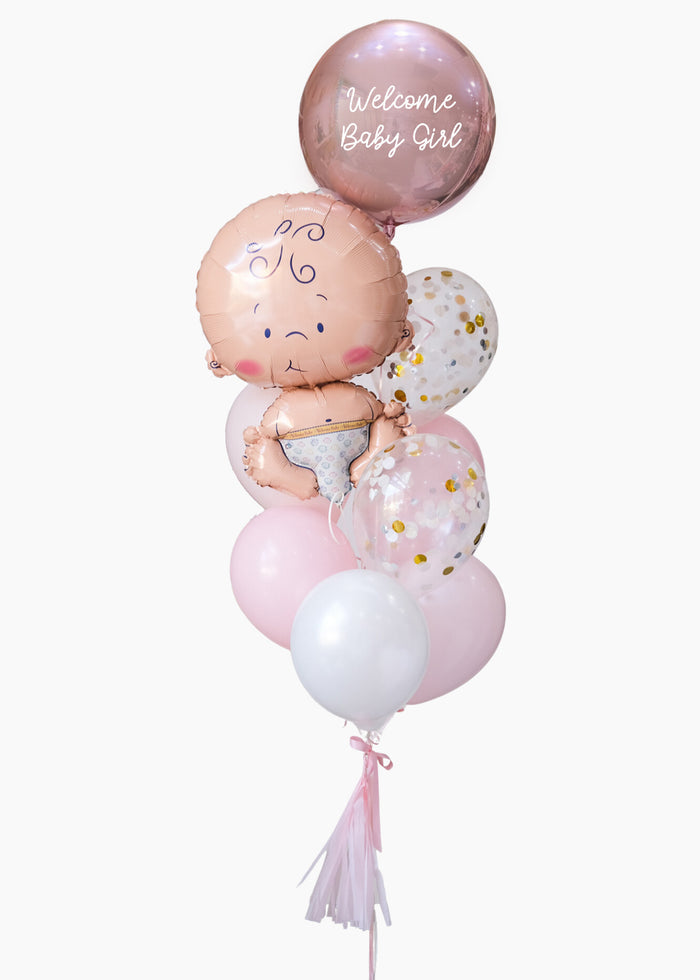 A baby balloon bouquet with a light skin baby and mixed pink latex and mylar balloons