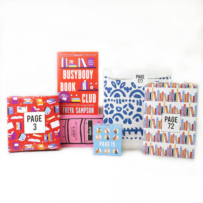 A paperback edition of The Busybody Book Club stands on a pink OUABC box. In front of the box are four themed wrapped gifts labeled with page numbers.