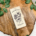 Phone case with enemies to lovers design on a wooden surface with leaves