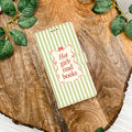 Notebook with 'Hot girl read books' text on a wooden surface with green leaves.