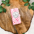 The front cover of a book-shaped phone case inspired by Sense and Sensibility by Jane Austen. The phone case sits on a wood slice surrounded by greenery.