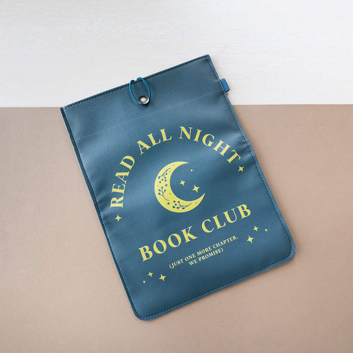 A booksleeve sits on a two-toned background. This booksleeve reads "Read All Night Book Club (just one more chapter, we promise)" in yellow font on a navy background and a yellow moon and stars.