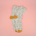 A pair of light blue socks with a gold and white pattern on them.