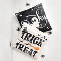 Halloween pillowcases with "Spooky" and "Trick or Treat" designs, accented with plastic spiders.