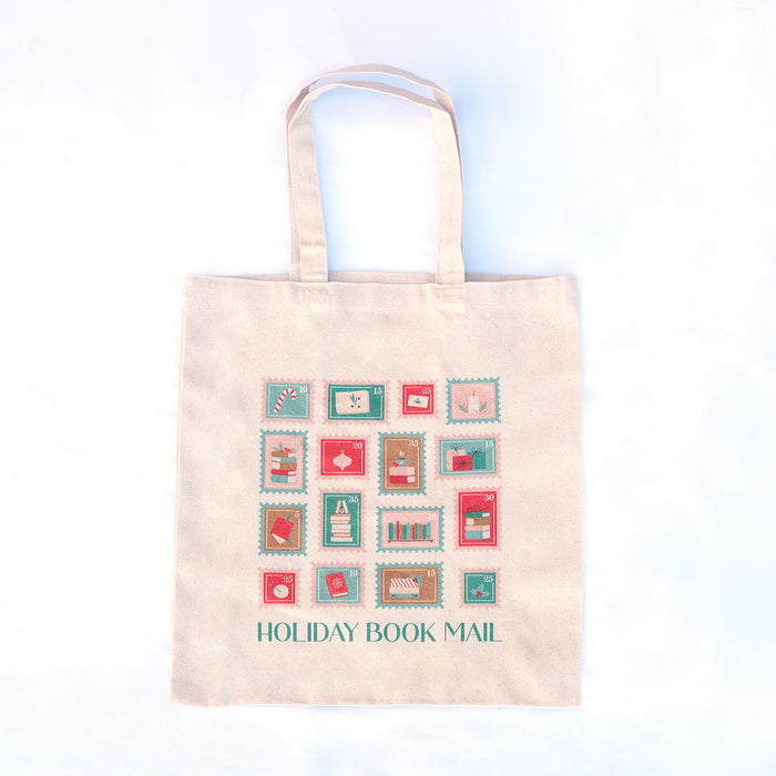 Tote bag with 'Holiday Book Mail' design featuring postage stamp-like graphics on a light background