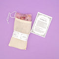 a woven bag contain an array of bath salts and flowers, along with instructions of how to use your bath tea.