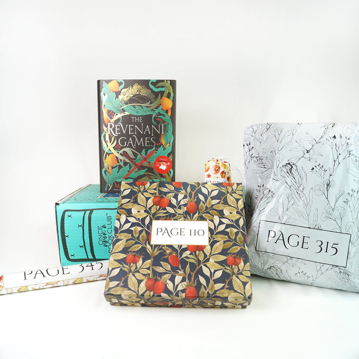 A hardcover copy of The Revenant Games by Margie Fuston sits on top of a green Once Upon a Book Club young adult box. Surrounding this are four wrapped gifts labeled with page numbers