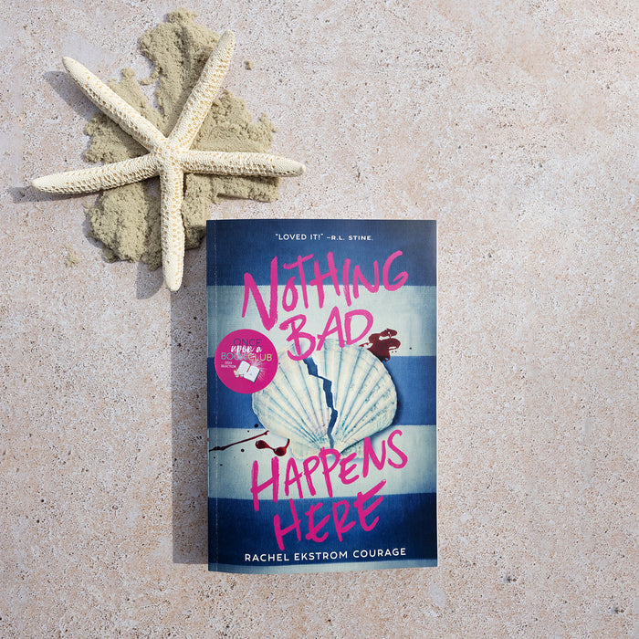 Book titled 'Nothing Bad Happens Here' by Rachel Ekstrom Courage on sand with a starfish.