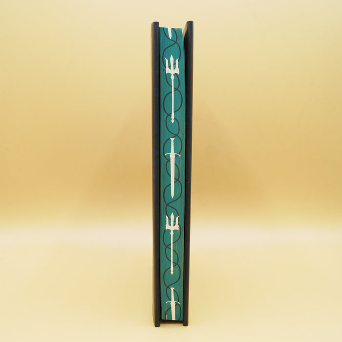 the page edges of a hardcover copy of Our Vengeful Souls. Page edges are teal with white tridents and swords