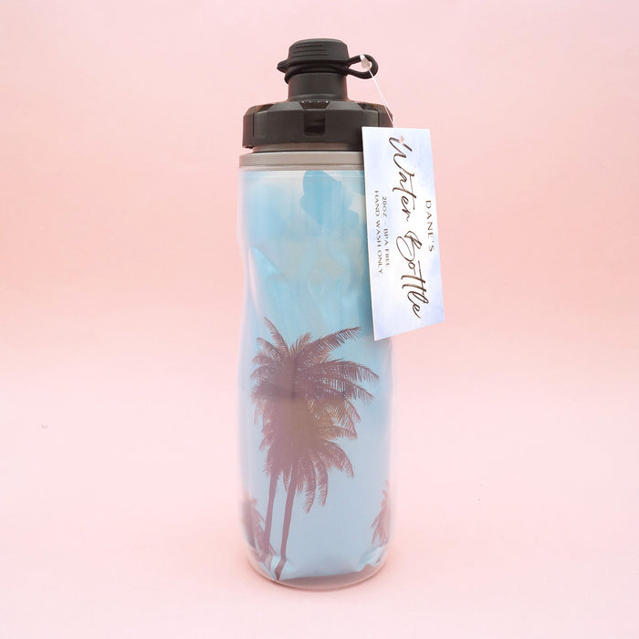 A double-lined water bottle with an image of a blue sky and palm trees on the inner line.