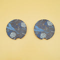 two black car coasters are next to each other with a pattern of blue leaves on them
