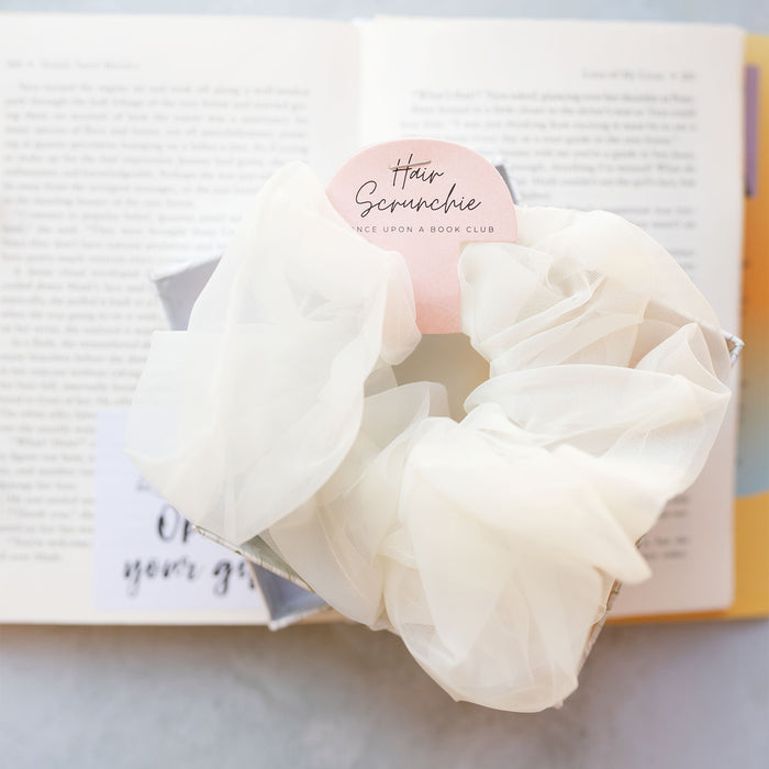 a white tulle scrunchie on an open book