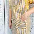 A gold and white striped apron with gold keys on the front