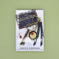 Book titled 'The Legacies' by Jessica Goodman with a keychain on a green background