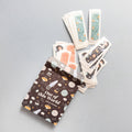 A box with spaceships and planets on it labeled "Out of this World adhesive bandages" has space-themed bandages coming out of the top