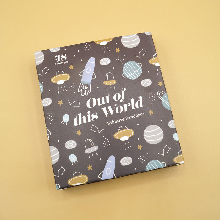 A box with spaceships and planets on it labeled "Out of this World adhesive bandages"