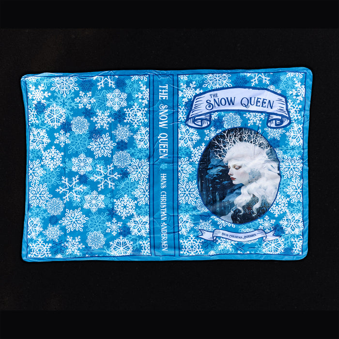 The outside of the Snow Queen blanket showcasing blue and white snowflakes and a portrait of the Snow Queen as well as the spine of the book.
