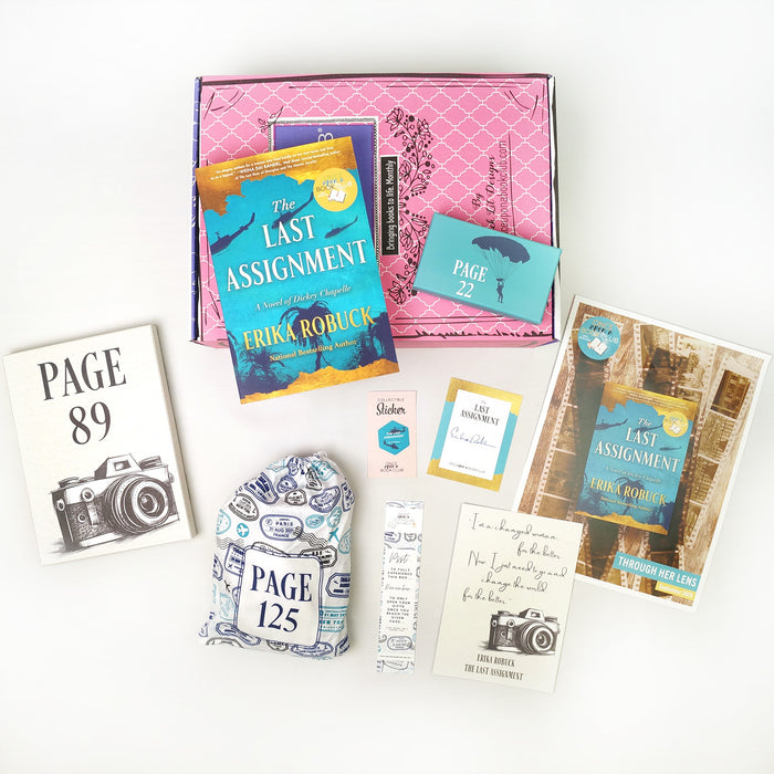A paperback copy of The Last Assignment by Erika Robuck surrounded by wrapped gifts labeled with page numbers and paper items.