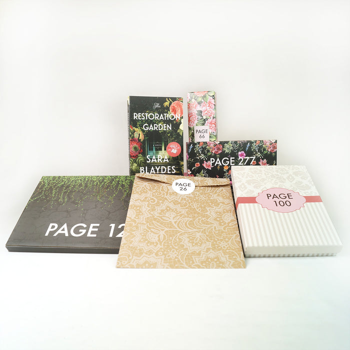 A paperback copy of The Restoration Garden by Sara Blaydes surrounded by wrapped gifts labeled with page numbers