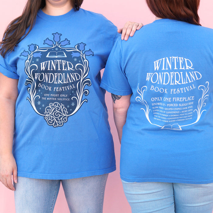 Two people wearing blue t-shirts with 'Winter Wonderland Book Festival' text and design.