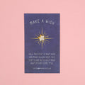 A small white star on a backing card that says 'Make a Wish! Hold this star in your hand and make a wish! Keep this star close by to help make your dreams come true.'