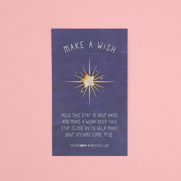 A small white star on a backing card that says 'Make a Wish! Hold this star in your hand and make a wish! Keep this star close by to help make your dreams come true.'